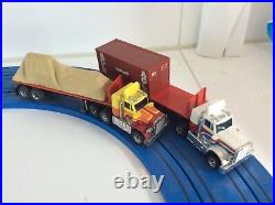 Aurora AFX Peterbilt trucks plus load on blue track